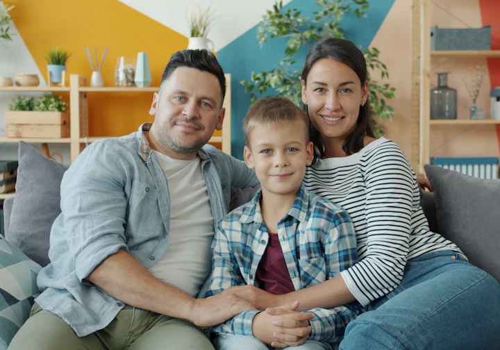 Família feliz reunida no sofá de casa