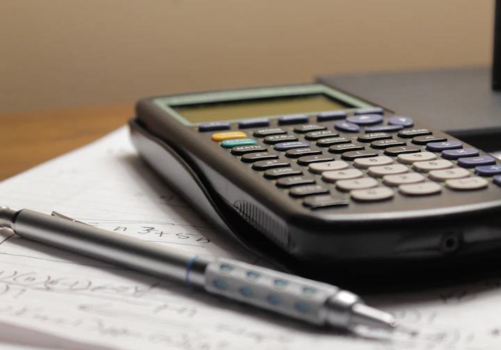Calculadora e caneta sobre documentos fiscais