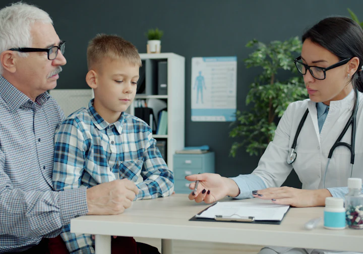Médica atendendo avô e neto no consultório