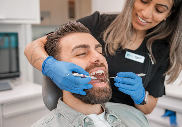 Dentista atendendo um paciente sorridente