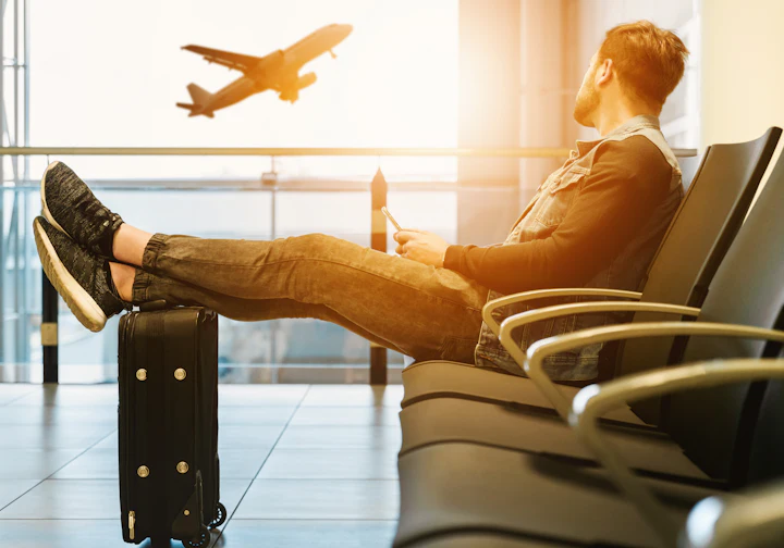 Viajante descansando no aeroporto com o avião decolando ao fundo